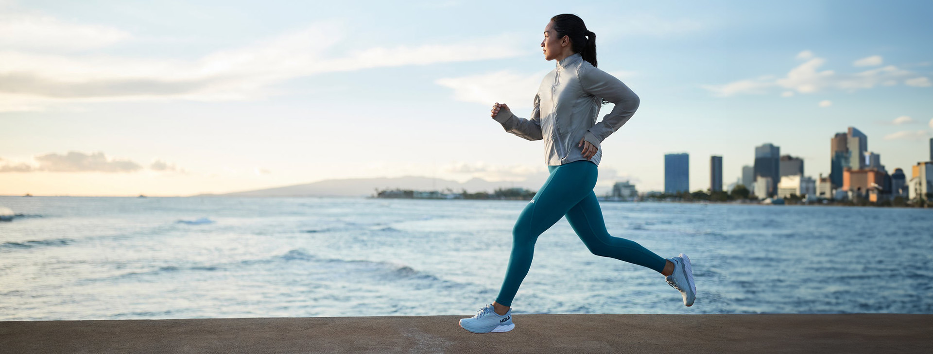 a woman running on a concrete surface by wat